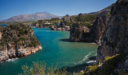 Obraz premium View across tranquil cove to the Faraglioni, Scopello