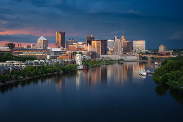 Obraz premium Saint Paul, Minnesota, USA. Aerial cityscape image of downtown St. Paul, Minnesota, USA with reflection of the skyline in Mississippi River at stormy summer sunset.