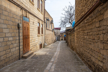 Old houses made of shell stone. The stone walls of the house are made of limestone blocks. The streets are paved with slabs of natural stone. The quarters of the ancient city with narrow streets.