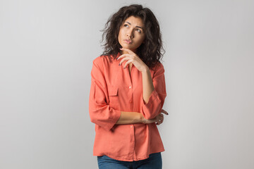 portrait of young thoughtful brunette woman in orange shirt, curly hair, summer style, frustrated face expression, looking up, thinking, problem, idea, mixed race, isolated