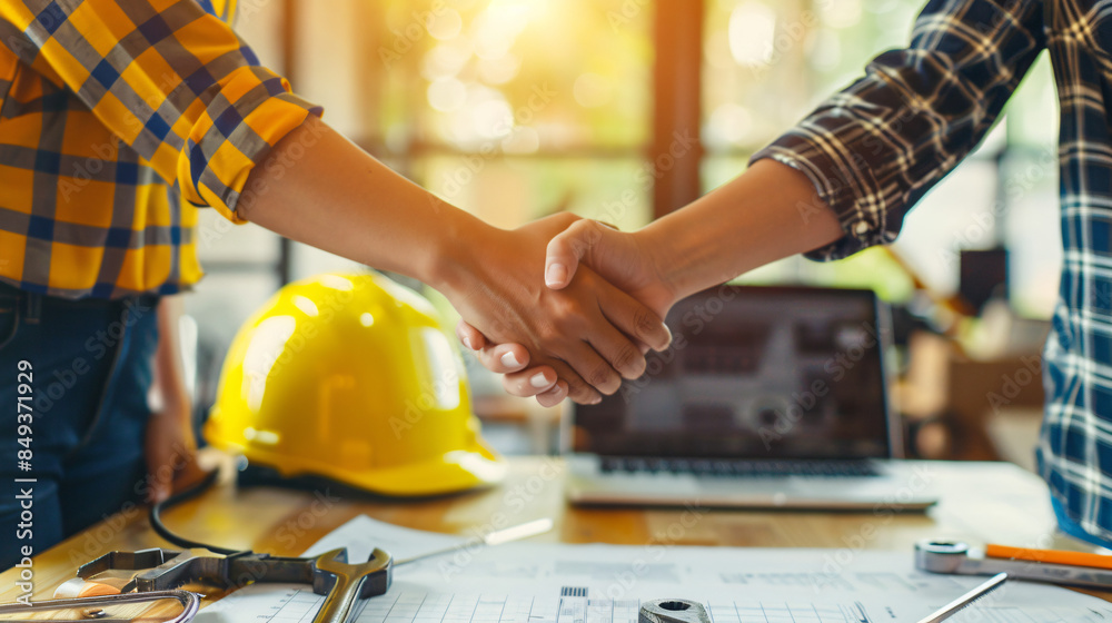 Poster Close-up of a handshake at a construction site with tools and blueprints