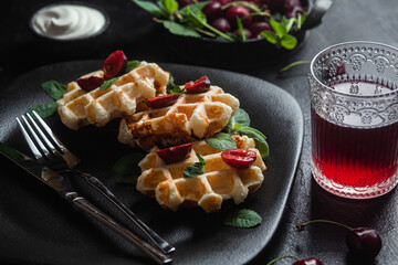 Viennese waffles with cherries on a dark background. Belgian waffles