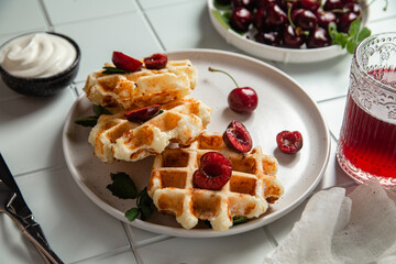 Viennese waffles with cherries on a dark background. Belgian waffles