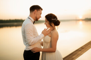 Obraz premium bride and groom against the backdrop of a yellow sunset