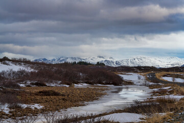 The wild rugged and natural landscape in Borgarbyggð is spectacular in winter with snow and ice and some beautiful snow covered mountains in the background, Snaefellsnes peninsula, Iceland