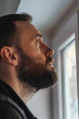 Obraz premium A person sitting at a window, gazing outside, possibly deep in thought