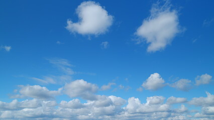 Obraz premium Beautiful sky background with picturesque cirrus and cumulus on different layers clouds. Blue sky called mare s tails indicate fine weather. Timelapse.
