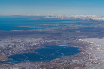 Aerial view of Kleivarvatn lake in the foregroung with the greater city of Reykjavik in the background, Iceland