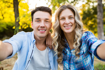 Fototapeta premium kissing young stylish couple sitting in park