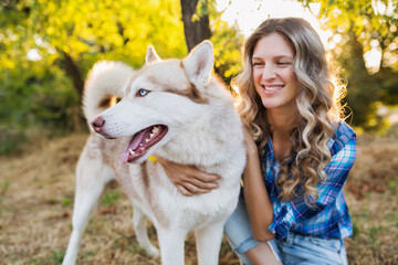 cool young stylish pretty smiling happy blond woman playing with dog