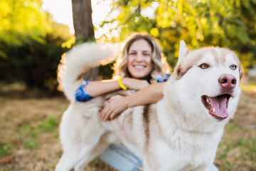 cool young stylish pretty smiling happy blond woman playing with dog