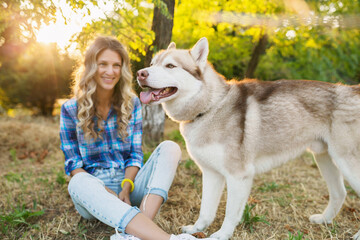 cool young stylish pretty smiling happy blond woman playing with dog