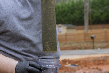 Maintenance worker replaces filter at domestic water treatment facility for residential water lines