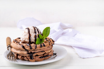 Stack of chocolate waffles with ice cream and topping