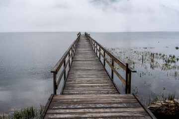 Obraz premium pier going into the lake in the fog early in the morning on Lake Teletskoye