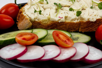 Sandwich with early spring vegetables and melted cheese close-up