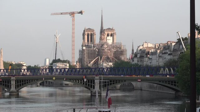 Pont de la Tournelle Bridge spans the Seine River, and the Notre Dame Cathedral in Paris, France