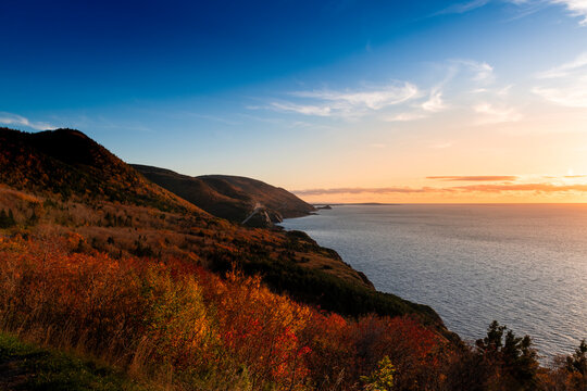 Scenic view of the coastline with the sea and mountains at the Cape Breton Highlands National Park, in Nova Scotia, Canada, at sunset.