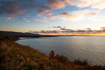Scenic view of the coastline with the sea and mountains at the Cape Breton Highlands National Park, in Nova Scotia, Canada, at sunset.