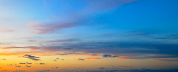The sunrise is decorated with clouds in various shapes. Wide photo.