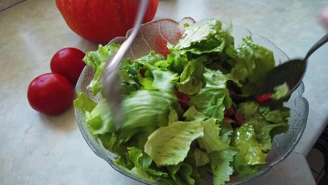 Toss a salad in a glass bowl