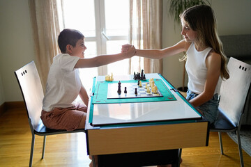 A boy and a girl are playing chess
