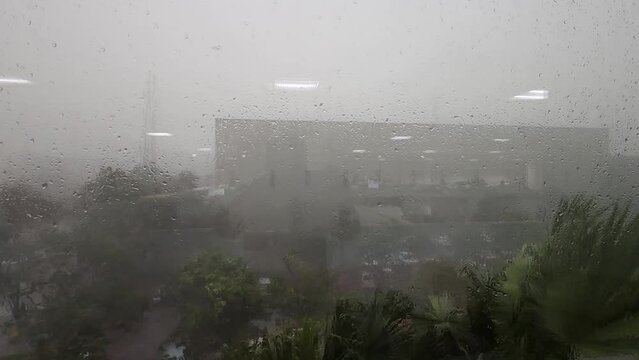 Capturing the essence of Mumbai&rsquo;s monsoon. Stunning view of heavy summer rain and strong winds as seen through an office window