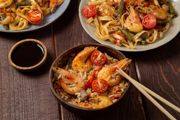 shrimp udon and rice yaki soba sauce on a round stand next to soy sauce and chopsticks