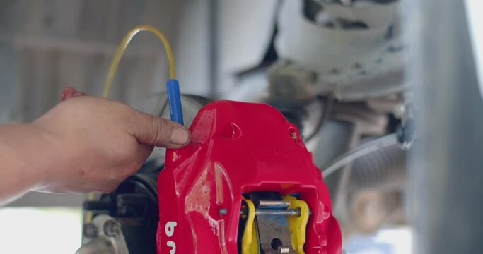 Brake fluid bleeding for new installations.Bleed brake fluid.Bleeding the brake fluid of the car's brake system.Technician changing fluid.