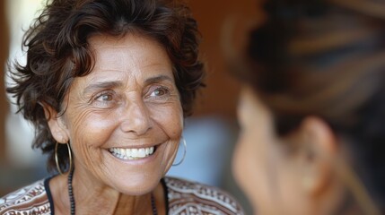 Fototapeta premium Smiling senior businesswoman talking with a colleague, engaging in a friendly conversation. The image captures a warm, positive interaction.