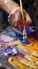 Fototapeta premium A close-up of a painter's hands mixing vibrant paint colors with a brush on a palette. The scene showcases the creativity and precision involved in the artistic process.