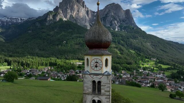 Ascending drone shot of a majestic church Chiesa di San Valentino nestled amidst stunning mountains