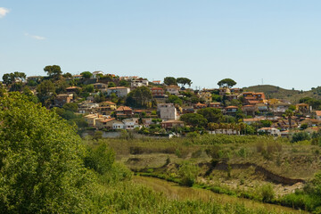 Fototapeta premium Hillside Village in Spain With Lush Vegetation and a Stream