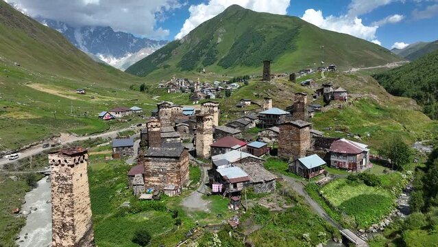 Aerial drone view of the Ushguli village with Svan towers in Svaneti region in Georgia. Medieval stone tower houses with Caucasus Mountains at background. Highest inhabited settlements in Europe