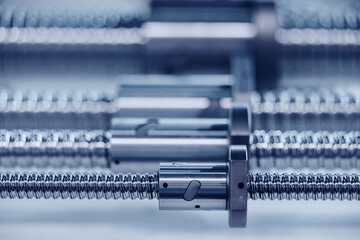 Metal guides with large threads for CNC machine drive. Industrial background blue toning, concept fix service