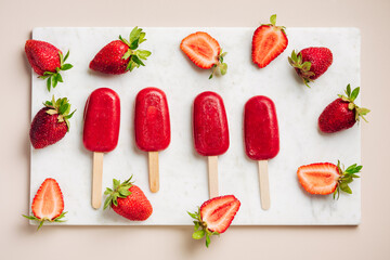 Strawberry popsicle ice cream and fresh strawberries.
