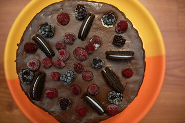 chocolate cake with three chocolates, fresh berries on the cake. cake poured with chocolate, the most chocolate cake