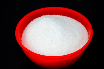 salt in red bowl, isolated in black background