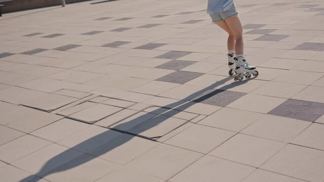 Person rollerblading on a paved surface during a sunny day. Concept of outdoor activities, freedom, and active lifestyle.