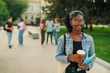 Happy diverse exchange college student girl at campus looking at camera