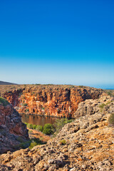 Fototapeta premium Heavily eroded red limestone rocks at the gorge of the Yardie Creek in Cape Range National Park, Western Australia, 
