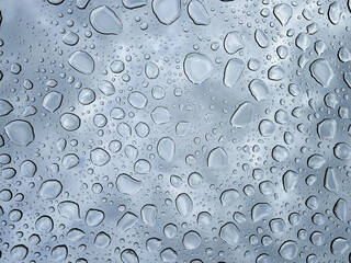 water drops through glass against a gray sky