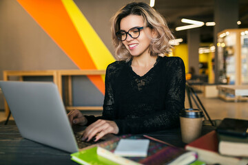 young woman working on laptop in co-working office