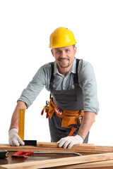 Male carpenter measuring wooden plank at table on white background