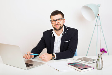 young handsome stylish hipster man in black jacket working at office table