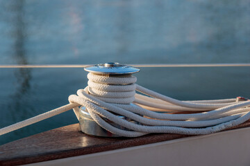 Sailboat winch with rope on yacht deck. Detail, low depth of focus. Leasure activities and extreme sport