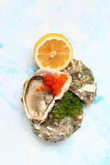 Tasty oysters with lemon and red caviar on blue background