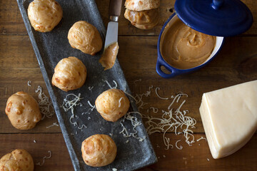 Pão de queijo stuffed with dulce de leche on a wooden tray. Soft and crispy pão de queijo filled with creamy dulce de leche on a wooden tray. A delicious and irresistible snack 