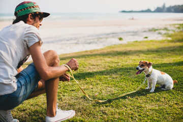 young stylish hipster man walking playing dog puppy jack russell