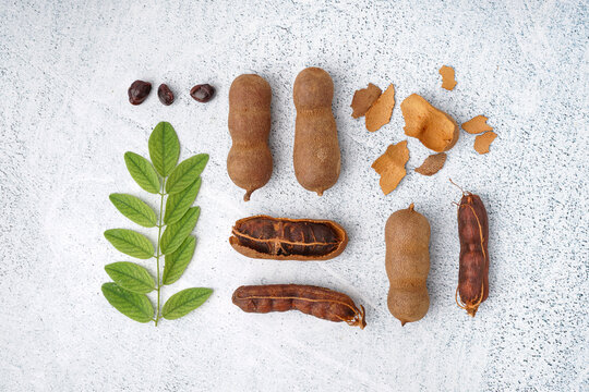 Tasty tamarinds, shell, seeds and leaf on white background